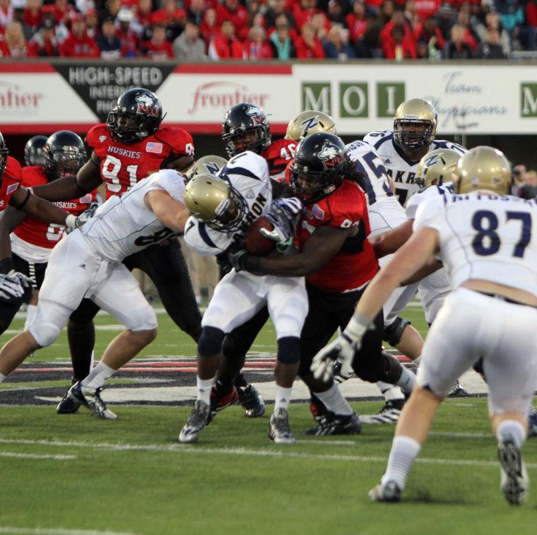 Former defensive tackle Ken Bishop tackles Akron Zips running back Jawon Chisholm Oct. 12 at Huskie Stadium. The Huskies lost their starting front four, and they have eight returning defensive linemen who saw playing time last season and six returning defensive linemen who didn’t play last season to fill the hole.