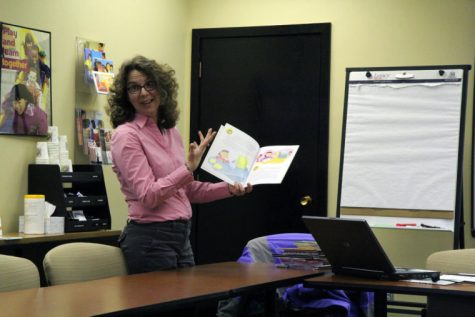 Mary Beth Henning, Center of Economic Education co-director, holds up a children’s book called