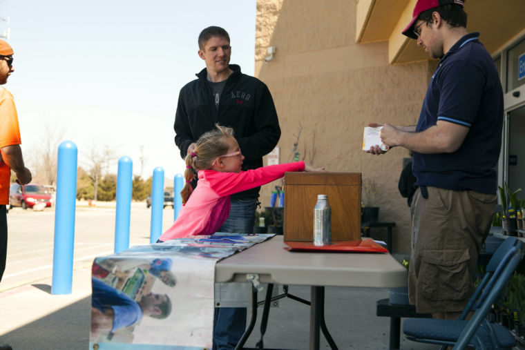Lily Provost, 5, of DeKalb, with father Tim Provost makes a donation toward Feed’em Soup while David Gordon (right), junior organization and corporate communication major, mans the donation table in front of Walmart, 2300 Sycamore Road. Rent and utilities have made it difficult for the charity, which provides locals with cheap food, to pay its bills.
