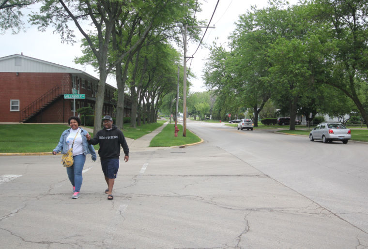 Two residents walk down Normal Road Friday. The neighborhood around St. Paul’s Episcopal Church on Normal Road is planning to start a summer farmers market. The market will feature a pay-as-you-can system, among other amenities.
