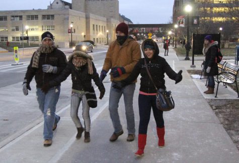 Students bear cold winds Tuesday on Normal Road in front of the Holmes Student Center. Climatology professor Dave Changnon said temperatures will begin to rise to above freezing Monday.