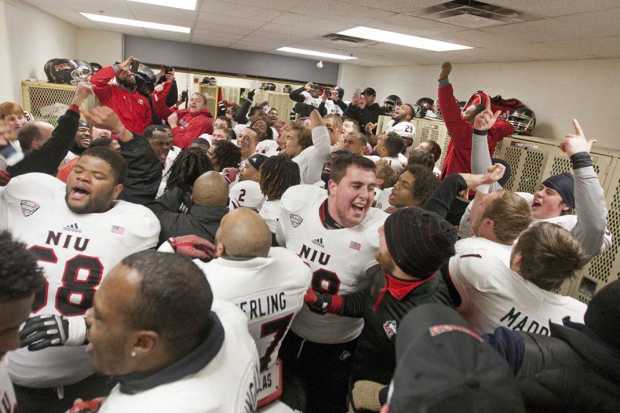 NIU football players celebrate in the locker room after beating the Western Michigan Broncos Friday at Waldo Stadium in Kalamazoo, Mich. NIU won, 31-21.