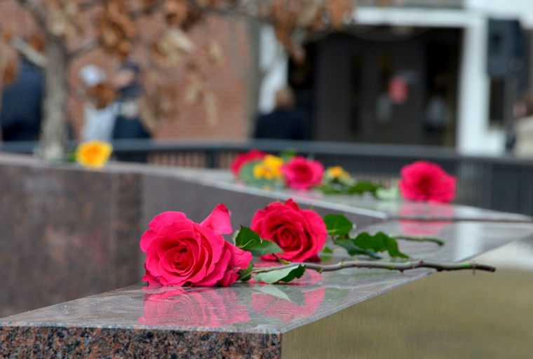 Loved ones of the five victims of the Feb. 14, 2008, shootings put roses on the Cole Hall memorial during the wreath-laying ceremony in 2013.