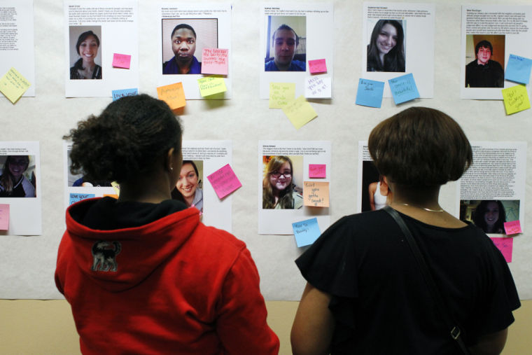 Students look at selfies, their descriptions and encouraging Post-it notes other left behind during the Self-ie-Perspective event Wednesday night in Neptune Central.