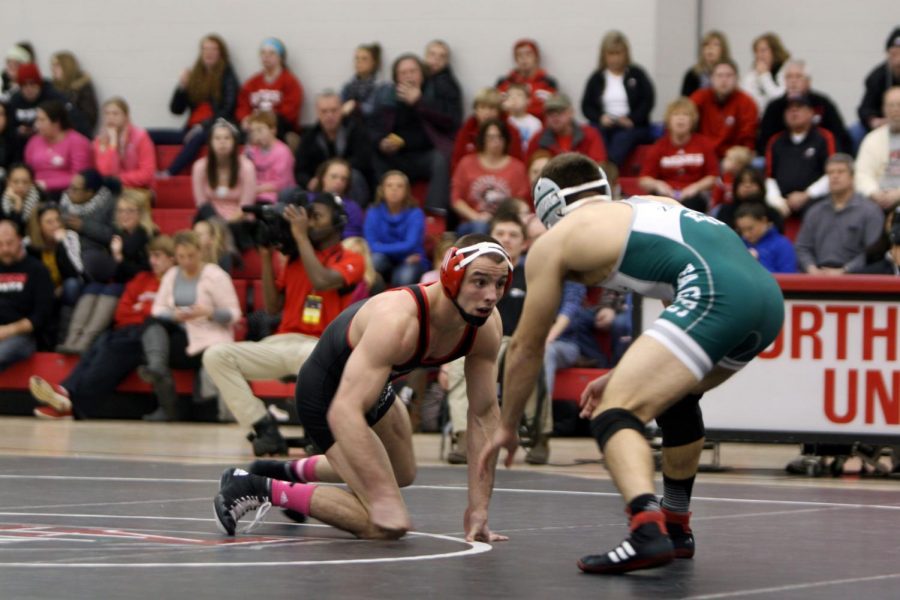 Junior Andrew Morse (157) looks for an opening to shoot in on Eastern Michigan’s Brandon Zeerip during Friday’s dual at Victor E. Court. Morse lost by a 3-2 decision, but the Huskies beat the Eagles, 21-12.