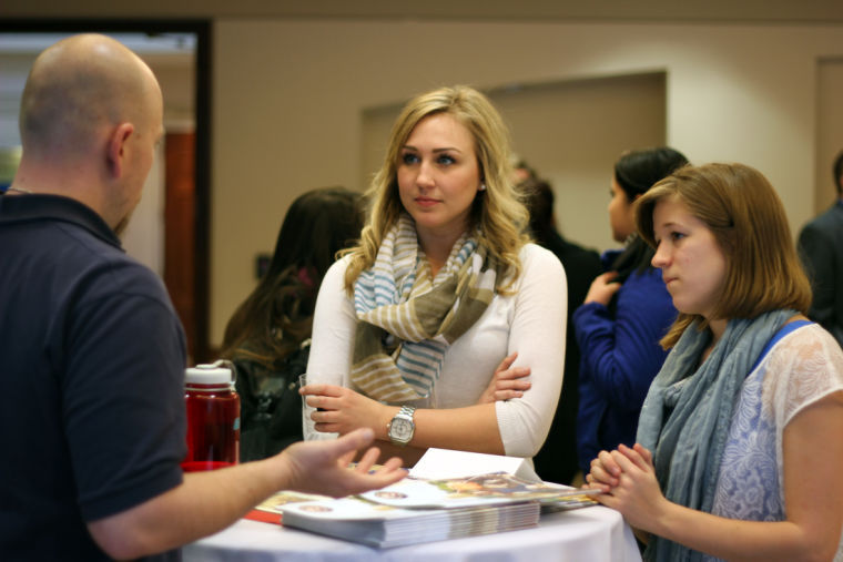 Senior marketing major Laine Smid (left) and sophomore accountancy major Chloe Pooler (right) converse with Rok Teasley of the Peace Corps Monday at Careers for a CAUSE. The Peace Corps was one of several organizations and businesses that attended Careers for a CAUSE at the Barsema Alumni & Visitor’s Center. The event encouraged students to attend so they could network with companies and executives.