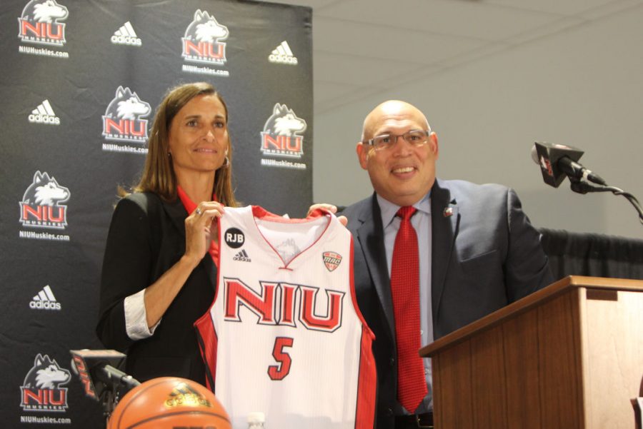 Lisa+Carlsen%2C+women%E2%80%99s+basketball+head+coach%2C+and+Athletics+Director+Sean+Frazier+pose+with+a+Huskie+jersey+Tuesday+at+a+press+conference.+Carlsen+joins+the+Huskies+from+Lewis+University%2C+where+she+coached+since+2007.