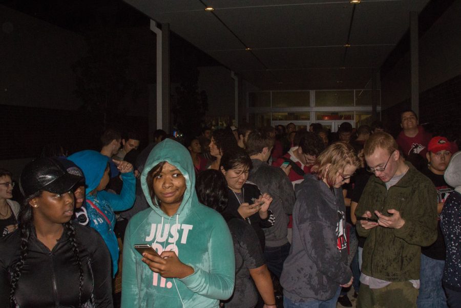 Students wait underneath the pavilion attached to the Yordon Center while being led to the Convocation Center during a bomb threat Thursday. NIU police said the threat appeared to be a hoax.