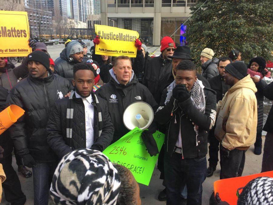 Amirius Clinton (left), junior political science major, stands beside Father Michael Pfleger and other protestors during the Peace March on Dec. 31 in Chicago. Clinton said an unlawful assemblies ordinance by the City Council is in response to past student protests involving NIU students, such as Black Lives Matter protests and the Peace March.