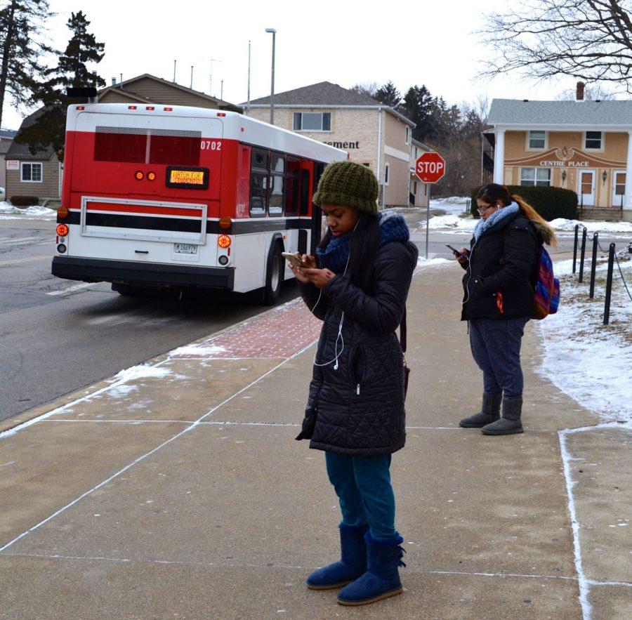 Shaiquale Thompson (left), junior child development major, and junior biology major Jackie Tulian wait for their bus outside of the Holmes Student Center on Friday. ETA Spot, a new tracking app for the HuskieLine, is now available on iTunes and on the Android App store.