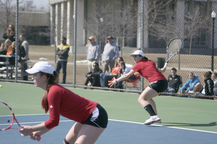Then-freshman Christina Alvarez returns a serve on March 29, 2013 in a doubles match versus Bowling Green University at the Huskie Tennis Courts as then-sophomore Stephanie McDonald stands ready for the volley.