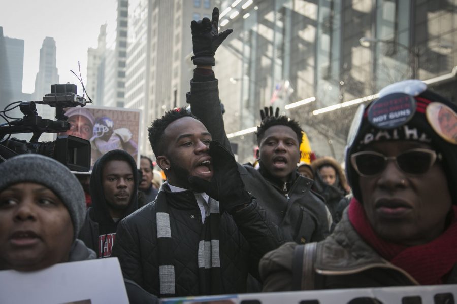 NIU junior Alirius Clinton, friend of Quintonio LeGrier who was shot and killed by Chicago Police Dec. 26, protests with Father Michael Pfleger against gun violence in Chicago on Michigan Avenue on Dec. 31. LeGrier’s high school and NIU’s Black Male Initiative plan to create a scholarship and GPA club, respectively, to commemorate his accomplishments.