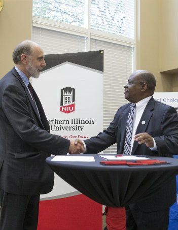 NIU President Doug Baker (left) shakes hands with David Sam, President of Elgin Community College, after agreeing to a Business Dual Degree Program.