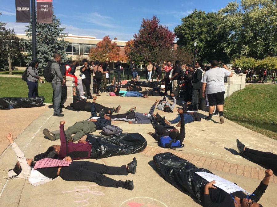 Demonstrators made up of Black Student Union members and students lay across a bridge to honor the Black Lives Matter movement outside Cole Hall around noon Tuesday. Some students wore garbage bags to represent those who died and others held signs with information about individuals who died at the hands of police. About 200 students stopped to watch the demonstration.