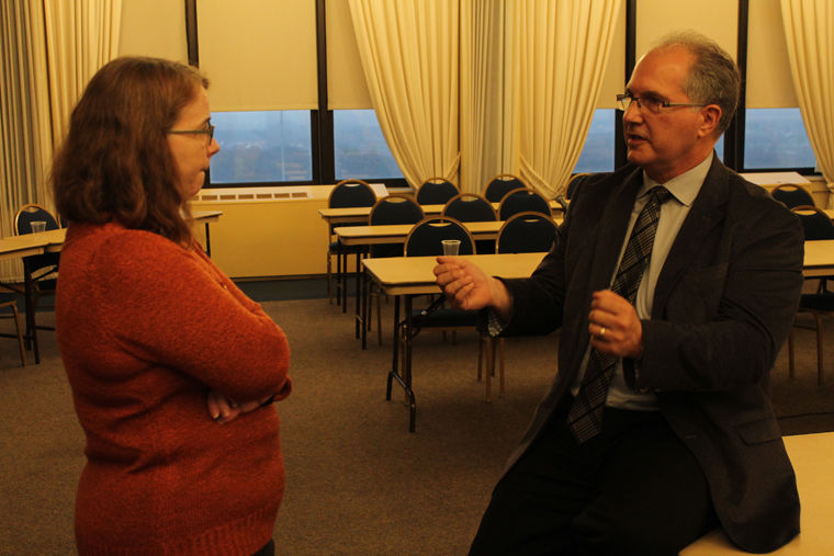 Therest Arado (left), deputy director of the College of Law Library, speaks with Greg Long (right), University Council executive secretary, about new programs, such as the Human Diversity requirement, being discussed at NIU.