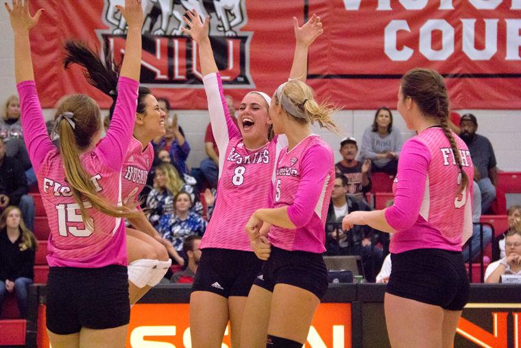 Members of the team celebrate a point in an Oct. 15 match against University of Akron. NIU won the match 3-2. 