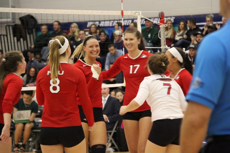 Members of the volleyball team celebrate after scoring in a Nov. 19 match against the University of Ohio on Victor E. Court. The Huskies defeated Ohio in straight sets to advance to the Mid-American Conference final. 