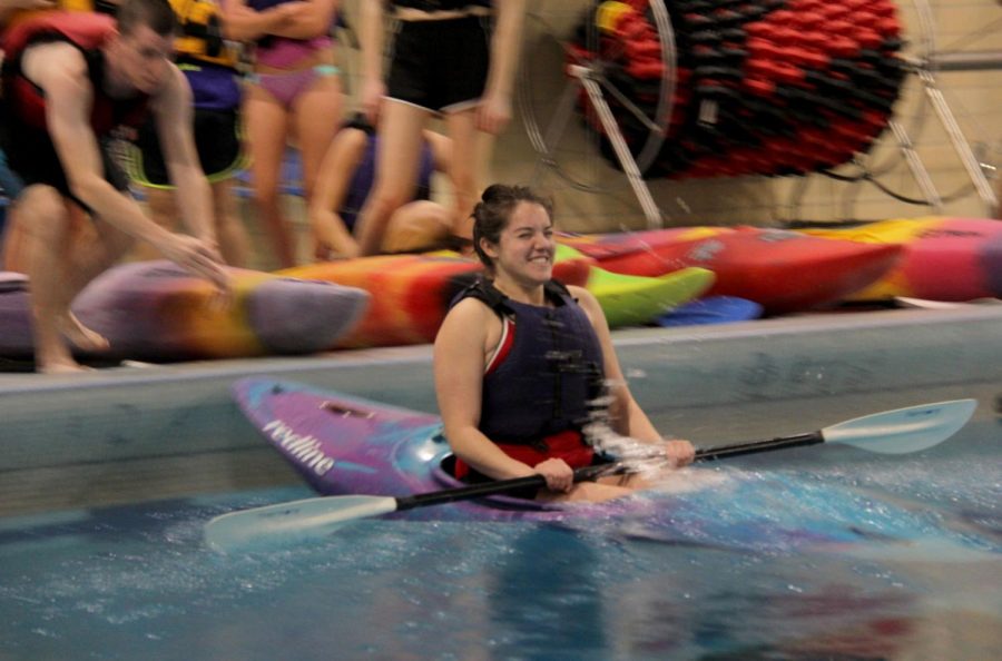 Corina Salinas, junior athletic training major, boards her kayak and lets instructors launch her into the water to begin the kayak pool workshop.
