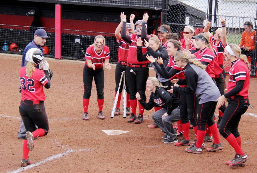 The team surrounds home plate after Senior Kali Kossakowski hit a home run during Saturday’s home game. The Huskies defeated the Bowling Green State University in two out of three games to win the weekend series. 