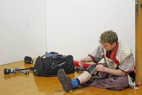 Treasurer Lincoln Held puts on his knee pads before starting practice. Due to the fast pace of this sport, participants must take a knee pretty quickly if their leg is hit.
