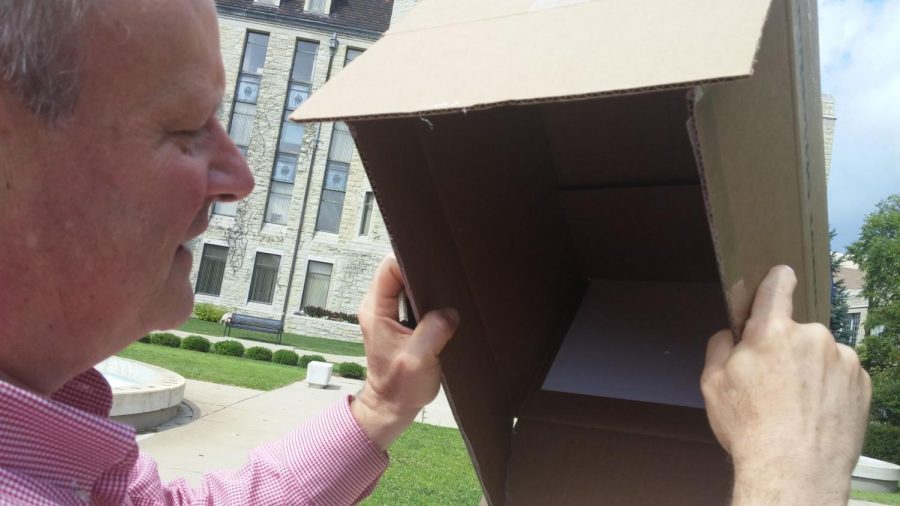 Physics department chairperson Laurence Lurio demonstrates how a cardboard box can be used to view Mondays partial solar eclipse. 
