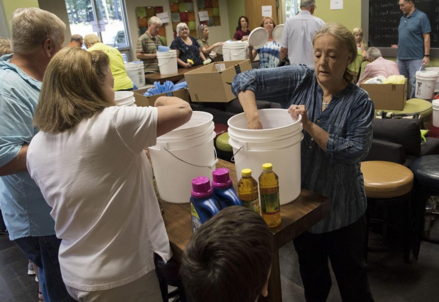 Candy Dellendy places detergent into buckets during a flood bucket making event Thursday at Dayspring United Methodist Church in Tyler, Texas. The large buckets contained household items which will be given to people who are cleaning up their houses after flood damage from Hurricane Harvey. NIU athletes have gathered similar donations for victims.