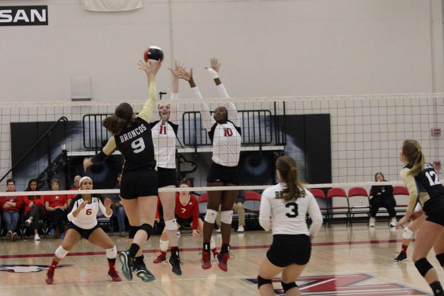 Sophomore middle blocker Brinley Milbrath (left) and Chrystal McAlpin, redshirt junior middle blocker (right), go up for a block in their home game Oct. 25 against Western Michigan. 