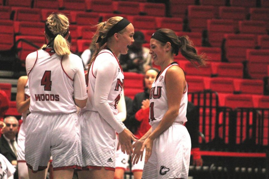 Junior guard Courtney Woods (left), senior forward Kelly Smith (center) and junior guard Mikayla Voigt (right) celebrate a play in the Huskies’ 98-28 home win Nov. 4 against Benedictine.