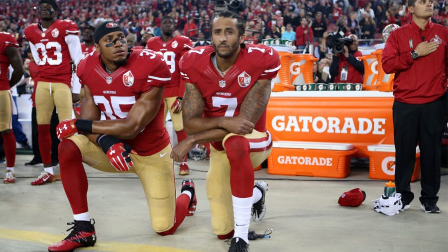 San Francisco 49ers quarterback Colin Kaepernick, left, and teammate kneel during the national anthem before an NFL football game.