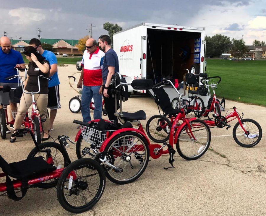 Participants adjust bikes to fit their measurements in demonstrating how to use the adapts-table bikes in the Health, Wellness and Literacy Center parking lot during the workshop Tuesday.