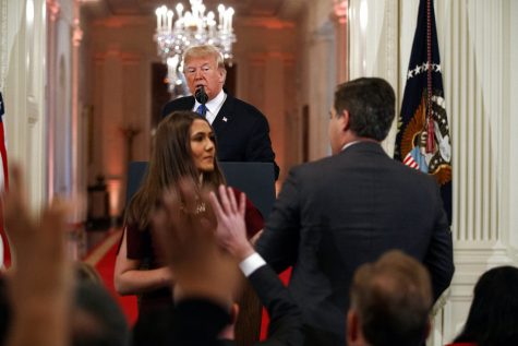 President Donald Trump watches as a White House aide takes away a microphone from CNN journalist Jim Acosta during a news conference in the East Room of the White House, Wednesday, Nov. 7, 2018, in Washington. (AP Photo/Evan Vucci)
