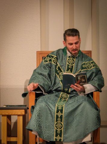 Father Kyle Manno reads and voices a few petitions during the 9 p.m. mass Sunday at the Newman Catholic Student Center, 512 Normal Road.