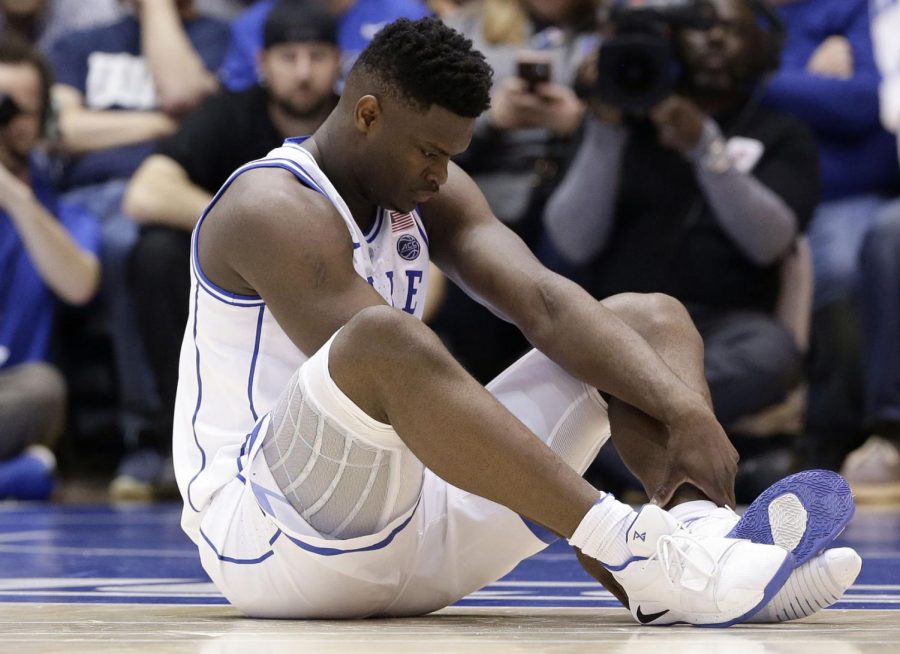 Dukes Zion Williamson sits on the floor following a injury during the first half of an NCAA college basketball game against North Carolina, in Durham, N.C., Wednesday, Feb. 20, 2019.