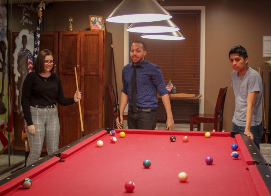 Public Relations Manager Elizabeth Warner (left), co-founder Kwamayne King and Project Phileo co-founder Brandon Soto (right) play pool Wednesday at American Legion, 1204 S. Fourth St.