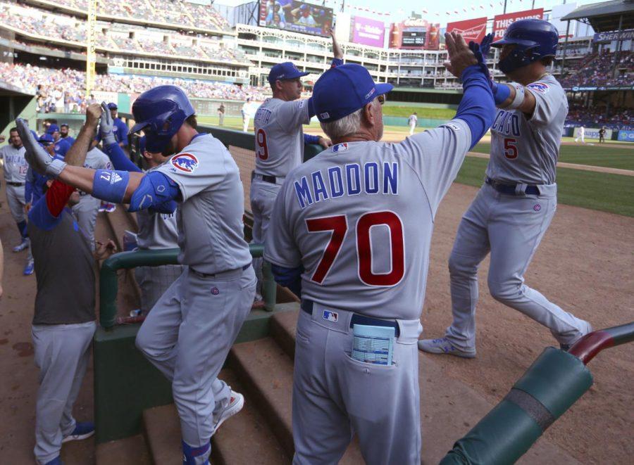 Chicago Cubs Kris Bryant (17) and Albert Almora Jr. (5) are greeted by manager Joe Maddon (70) after Bryants two-run home run in the eighth inning of a baseball game against the Texas Rangers Thursday, March 28, 2019 in Arlington, Texas.