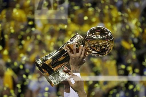 Golden State Warriors center JaVale McGee holds up the Larry OBrien NBA Championship Trophy after Game 5 of basketballs NBA Finals between the Warriors and the Cleveland Cavaliers in Oakland, Calif., Monday, June 12, 2017. The Warriors won 129-120 to win the NBA championship. (AP Photo/Marcio Jose Sanchez)