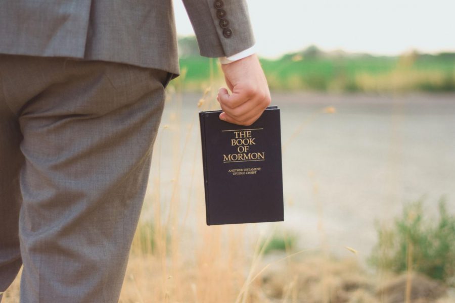 Missionary holding book of mormon