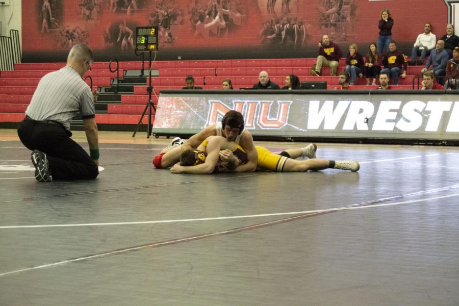 Redshirt first-year Anthony Gibson (top) attempts to pin his opponent Jan. 5 during NIUs 19-12 win over Central Michigan University at Victor E. Court.