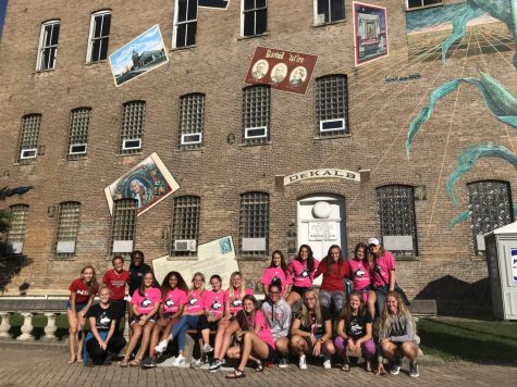The women's track and field and cross country team poses for a photo during its time volunteering at Corn Fest in downtown DeKalb.