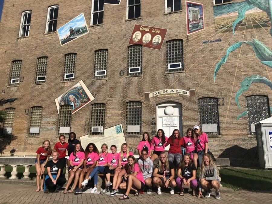 The womens track and field and cross country team poses for a photo during its time volunteering at Corn Fest in downtown DeKalb.