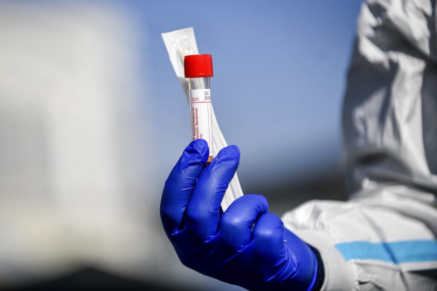 A medical personnel holds a kit for the test for Coronavirus outside one of the emergency structures that were set up to ease procedures outside the hospital of Brescia, Northern Italy, Tuesday.
