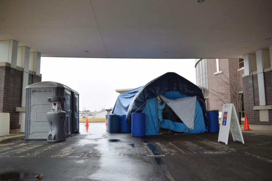 A nurse looks out of the flap of a tarp tent erected outside Kishwaukee Hospitals emergency wing, 1 Kish Hospital Drive. A nurse on-site said they are currently swabbing patients with cold- and flu-like symptoms.