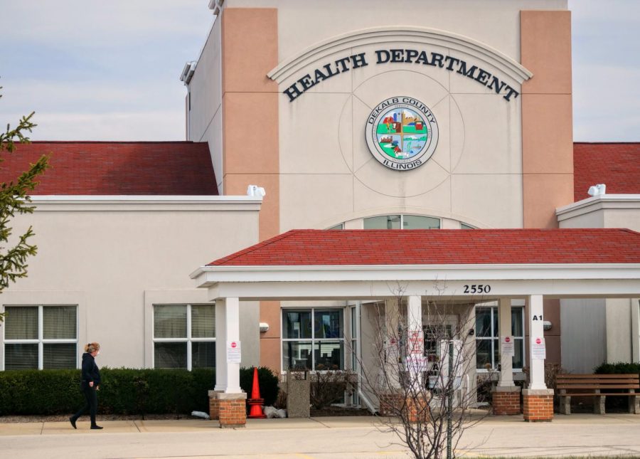 DeKalb County Health Department employee walks to her car with a mask on.