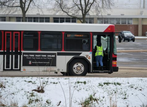 NIU bus driver waits at the bus stop on University Circle. NIU public transit, which includes the Huskie Line busses will no longer require masks. 