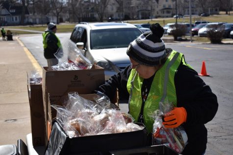 Cindy Rae, assistant at the Early Learning and Development Center, grabs bagels for a grab-and-go meal as a car pulls up to the drive-up booth.