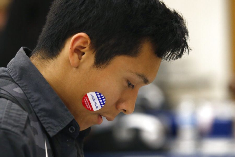 Angel Tapia displays his I Voted Today sticker as students participate in budget participation election March 5 at Maryvale High School in Phoenix.