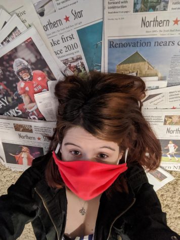 Editor in Chief Sam Malone lies on copies of the Northern Star with a mask covering her face.