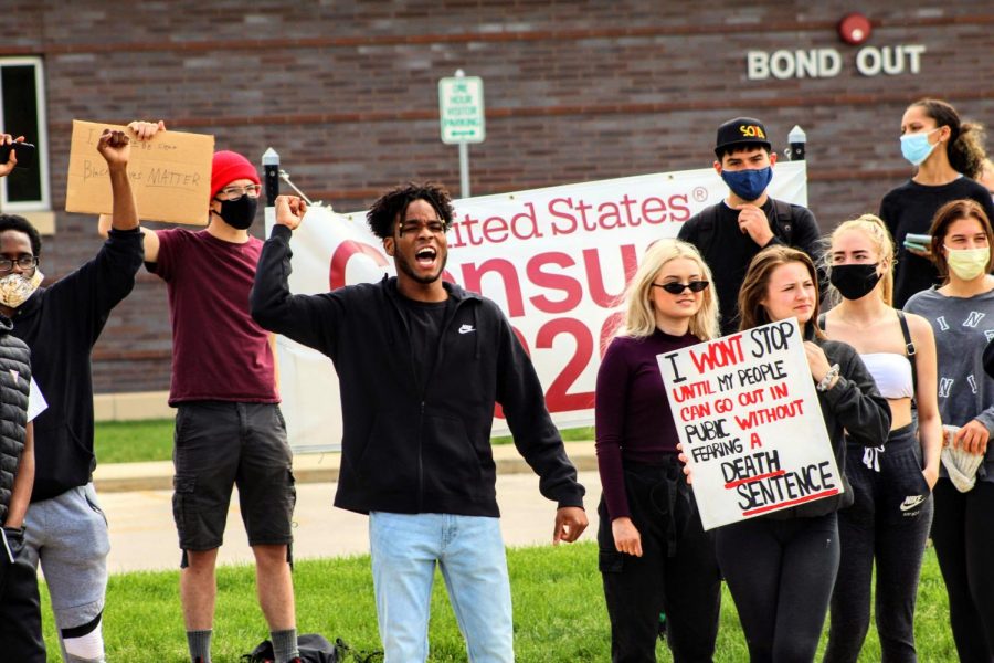 DeKalb community members gather Monday in front of the DeKalb Police Station, 700 W Lincoln Highway, to protest police brutality. 