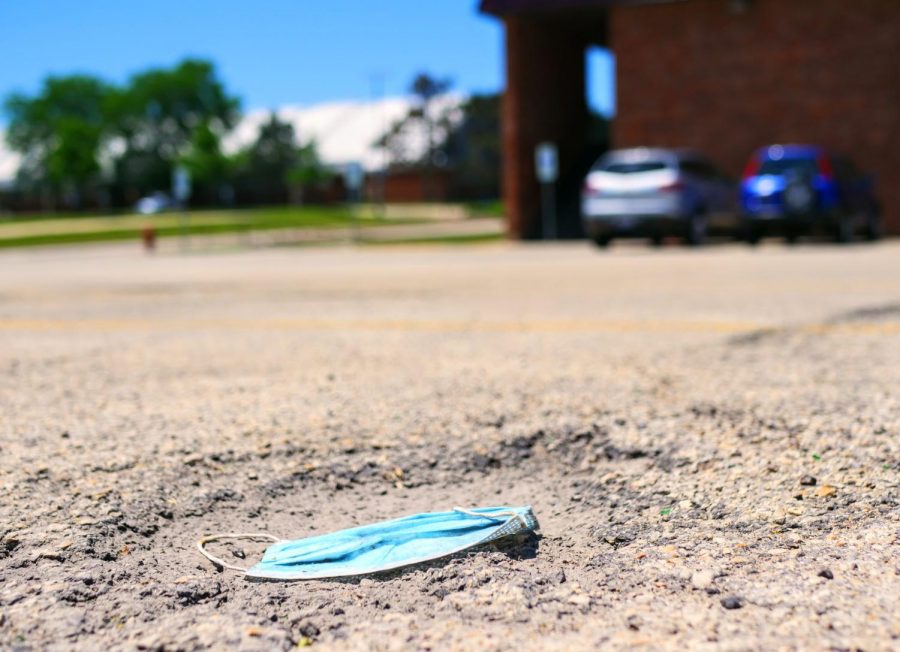 A discarded face mask lays in the parking lot outside the Village Commons Bookstore in DeKalb on Friday, June 12th.