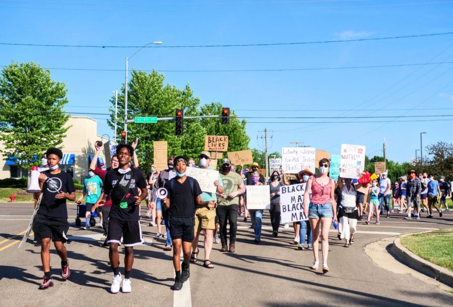 Andre Allen Jr., Anterrion Redd and Isaac Pierre lead a Juneteenth march down Sycamore Road in DeKalb on Friday.